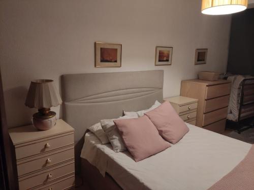 Un dormitorio con una cama con almohadas rosas. en Caparica Apartment near beach, en Costa da Caparica