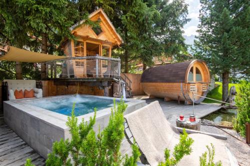 um quintal com uma banheira de hidromassagem e uma casa na árvore em Chalet Elisabeth dolomites alpin & charme em Selva di Val Gardena