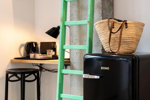 a green ladder next to a kitchen with a refrigerator at Espace 43 - Les 7 chambres in Namur
