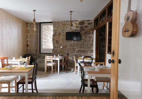 a restaurant with tables and chairs and a guitar at Casa da Praça - Guest House in Pinhel