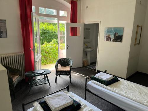 un salon avec un lit et une chaise dans l'établissement L'Etoile Maison d'hôtes Demi-pension, à La Bastide-Puylaurent