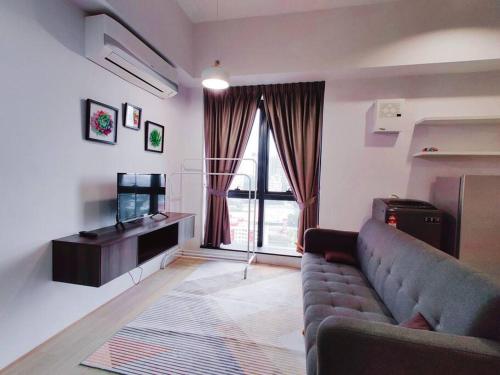 ein Wohnzimmer mit einem Sofa und einem TV in der Unterkunft 20 BukitJalil Pavilion - 2bedroom - HighFloor - 吉隆坡 in Kuala Lumpur