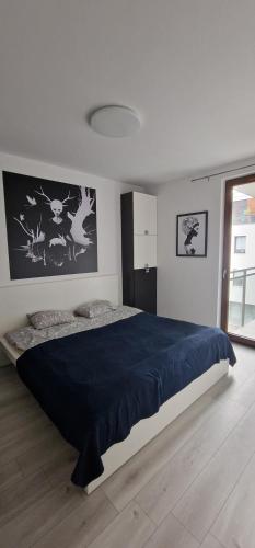 a bedroom with a large bed with a blue blanket at Apartments Apart 59 in Gdańsk