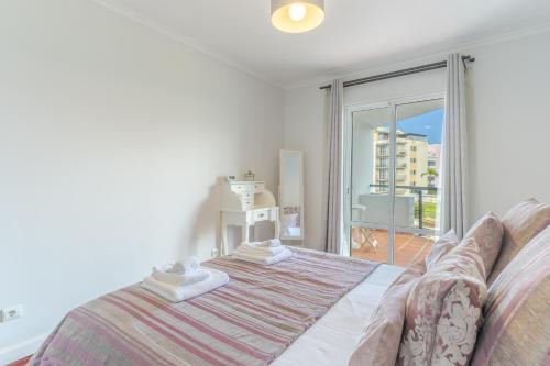 ein Schlafzimmer mit einem Bett und einem großen Fenster in der Unterkunft Forum Apartment in Funchal