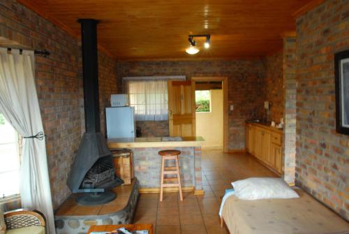 a living room with a brick wall and a stove at Thaba Tsweni Lodge & Safaris in Graskop