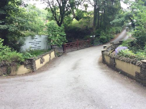 a dirt road with a fence and some flowers at Cwmbach Guest House in Neath