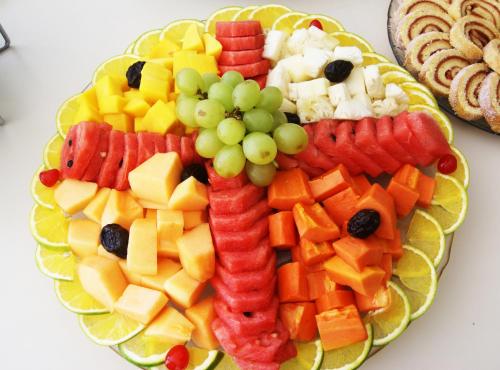 a plate of fruit and vegetables on a table at Hotel Diogo in Fortaleza