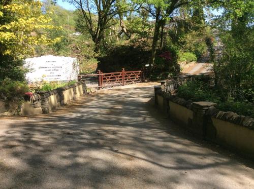 una carretera en un parque con una valla y árboles en Cwmbach Guest House en Neath