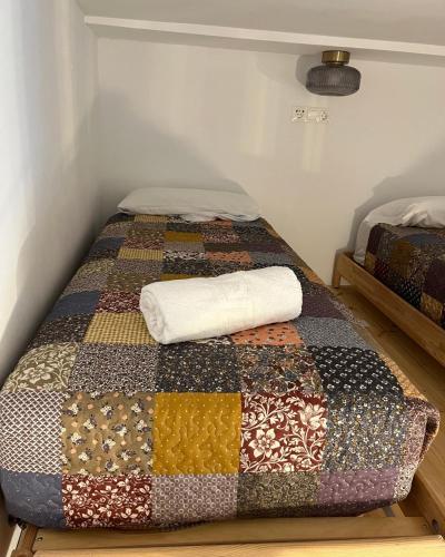 a bed with a quilt on it in a room at Apartamentos El Alcazar de Jerez in Jerez de la Frontera