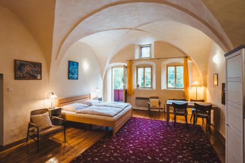 a bedroom with a bed and a table and chairs at Downtown Apartments in Český Krumlov