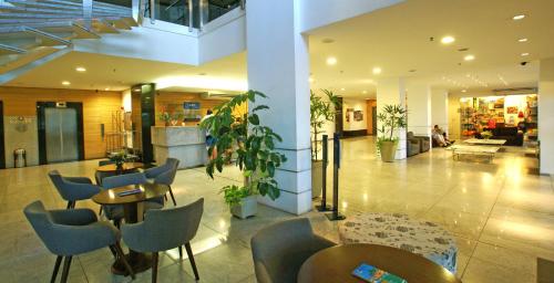 a lobby with tables and chairs in a building at Hotel Diogo in Fortaleza