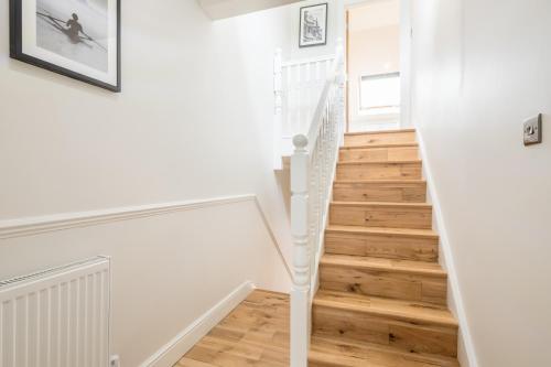 a staircase in a home with white walls and wooden floors at Tulse Hill Luxury Cosy Rooms in London