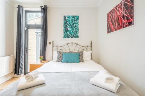 a bedroom with a large white bed with two pillows at Tulse Hill Luxury Cosy Rooms in London