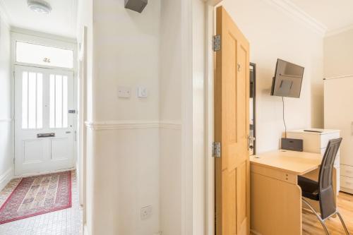 a room with a desk and a computer and a door at Tulse Hill Luxury Cosy Rooms in London