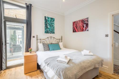 a bedroom with a bed with towels on it at Tulse Hill Luxury Cosy Rooms in London