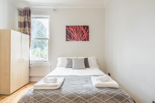 a bedroom with a bed in a white room at Tulse Hill Luxury Cosy Rooms in London