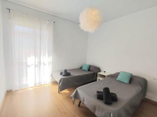 biały pokój z 2 łóżkami i lampą w obiekcie Moondaka w mieście Nerja