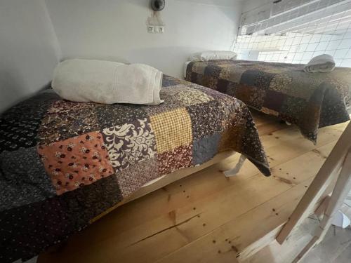 two twin beds in a room with wooden floors at Apartamentos El Alcazar de Jerez in Jerez de la Frontera