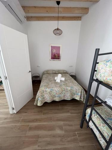 a small bedroom with a bed and a ladder at Apartamentos El Alcazar de Jerez in Jerez de la Frontera