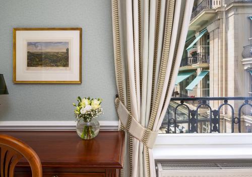 a vase of flowers on a table next to a balcony at Brenners Park Hotel & Spa, Oetker Hotels in Baden-Baden