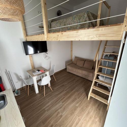 a small room with a bunk bed and a desk at Apartamentos El Alcazar de Jerez in Jerez de la Frontera