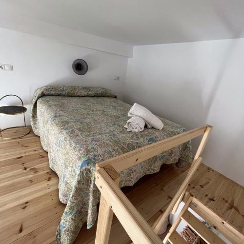 a bed in a room with a wooden floor at Apartamentos El Alcazar de Jerez in Jerez de la Frontera