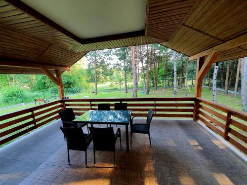 a screened in porch with a table and chairs at Trzy Sosny Płaska in Płaska
