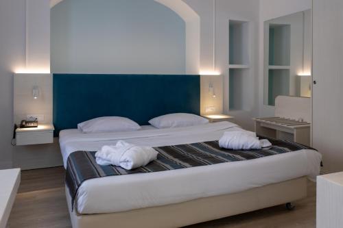 a hotel room with two beds and a white bedspread at Athens Cypria Hotel in Athens