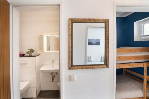ein Badezimmer mit einem Spiegel und einem Waschbecken in der Unterkunft Blankwasserweg 131 Lensterstrand Oase Bungalow 4 in Lenste