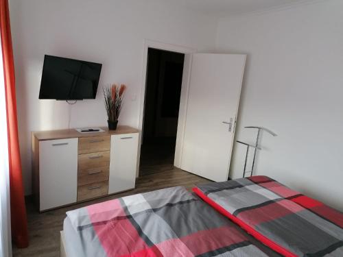 a bedroom with a bed and a tv on a dresser at Ferienwohnung in der Marktstraße in Mayen