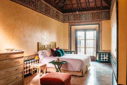 a bedroom with a large bed and a dresser at La casa del Cipres una casa con historia in Córdoba