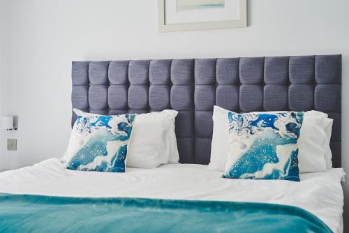 a bed with blue and white pillows on it at Chance Cottage in St Ives