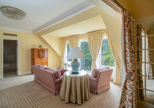 a living room with two chairs and a table at Brenners Park Hotel & Spa, Oetker Hotels in Baden-Baden