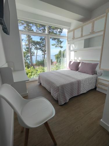 a bedroom with a bed and a chair and a window at HOSTAL FORMOSO in San Francisco
