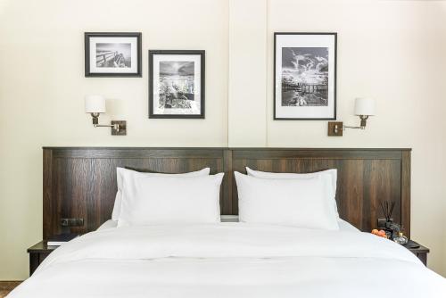 a bedroom with a large bed with white pillows at Kerpė Hotel & SPA in Palanga