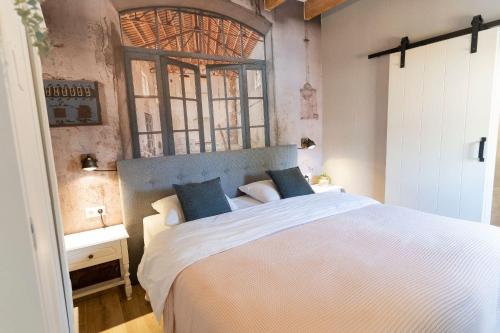 a bedroom with a large white bed with blue pillows at B&B The Wellness Cottage in Dordrecht