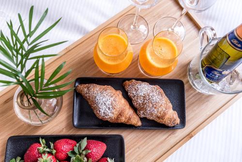 two plates of food with fruit and glasses of orange juice at Kerpė Hotel & SPA in Palanga
