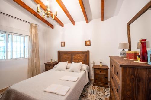 a bedroom with two beds and a dresser and a window at Cortijo Vélez in Trapiche