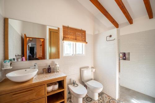 a bathroom with a sink and a toilet and a mirror at Cortijo Vélez in Trapiche