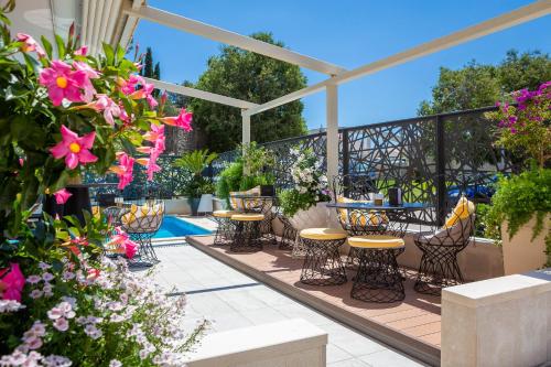 a patio with tables and chairs and flowers at Aparthotel Flora in Tučepi