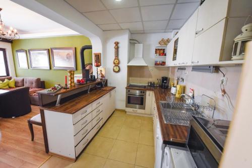 a kitchen with white cabinets and a living room at Jovanovic Guest House in Ohrid