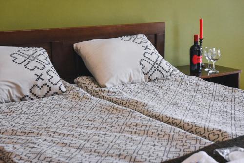 a bed with two pillows and a bottle of wine at Jovanovic Guest House in Ohrid
