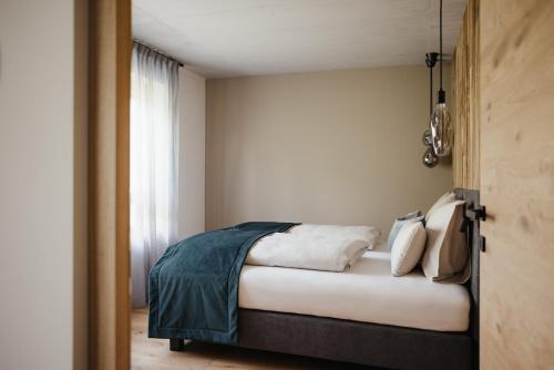 a bedroom with a bed with white sheets and pillows at Plattnerhof Viums in Natz-Schabs