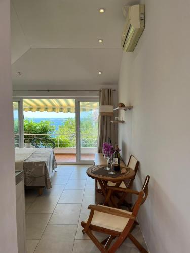 a room with a table and a bed and a table and chairs at Studio apartment SOL in Mlini