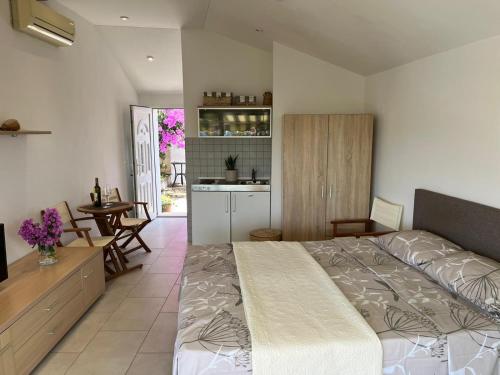 a bedroom with a large bed and a kitchen at Studio apartment SOL in Mlini