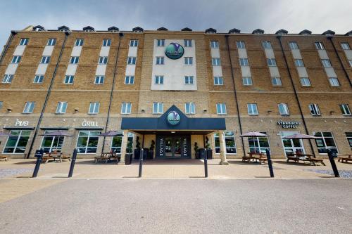 a hotel front of a building with tables and chairs at Village Hotel Bournemouth in Bournemouth