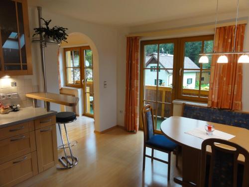 a kitchen with a table and chairs and a large window at Ferienwohnung Kogler in Strobl