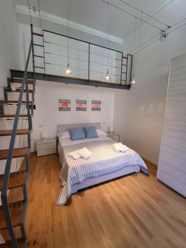 a bedroom with a bed with blue pillows and a ladder at GUVANO Luxury Apartments in La Spezia