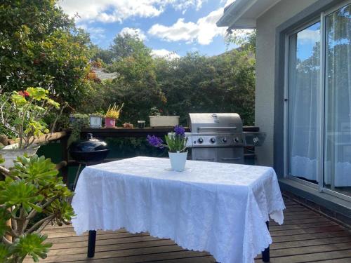 a table with a white table cloth on a patio at Caesar's Self-catering Open Plan Suite in Somerset West