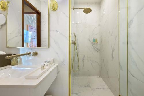 a white bathroom with a shower and a sink at Schloss Fellin Boutique Hotel and Spa in Viljandi